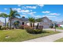 Charming home with a lush front yard, featuring mature palms and well-maintained landscaping and a paved driveway at 25221 Quail Croft Pl, Leesburg, FL 34748
