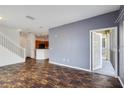 Open-concept living room with wood floors, gray accent wall, and access to outdoor screened-in patio at 2604 Grand Central Pkwy # 12, Orlando, FL 32839