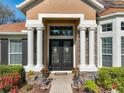 Inviting front entrance with decorative columns, stone accents, and a double door entry at 2805 Ponkan Meadow Dr, Apopka, FL 32712