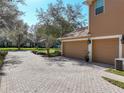 Large two-car garage with brick-paved driveway and manicured landscaping at 2805 Ponkan Meadow Dr, Apopka, FL 32712
