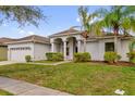 Well-maintained one story home featuring a manicured lawn and an elegant columned entryway at 2819 Boating Blvd, Kissimmee, FL 34746