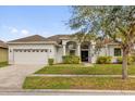 Charming one-story home with a manicured lawn, arched entryway, and two-car garage at 2819 Boating Blvd, Kissimmee, FL 34746