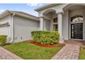 Close up of entryway featuring columns, arched window, brick walkway and manicured landscaping at 2819 Boating Blvd, Kissimmee, FL 34746