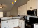 Bright kitchen featuring white cabinets, granite countertops, and black appliances at 3651 N Goldenrod Rd # 210, Winter Park, FL 32792