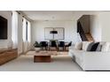 Modern living room with neutral tones, a wooden coffee table, large windows, and an adjacent dining area at 407 Calhoun Pl, Orlando, FL 32801