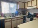 Functional kitchen featuring oak cabinets, laminate countertops, stainless steel sink, and modern appliances at 4419 S Semoran Blvd # 7, Orlando, FL 32822