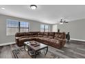 Spacious living room featuring a large leather sectional and modern flooring at 4521 Jim Glenn Dr, Orlando, FL 32808