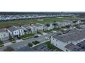 An aerial view showing a neighborhood with uniform houses, green lawns and landscaping, next to a green golf course at 561 Pebble Beach Dr, Davenport, FL 33896