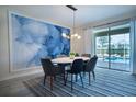 Open dining space with a modern light fixture, table with seating for six, and view of the pool at 561 Pebble Beach Dr, Davenport, FL 33896