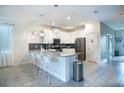 Bright, white kitchen with an island, stainless steel appliances, pendant lighting and a gray subway tile backsplash at 561 Pebble Beach Dr, Davenport, FL 33896