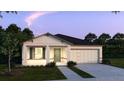 Single-Gathering home with a two-car garage, landscaping, and front entry under dusk lighting at 6634 Lullaby Way, Mascotte, FL 34753