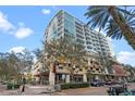 Modern condo building exterior with balconies, street-level retail, and lush greenery at 101 S Eola Dr # 1001, Orlando, FL 32801