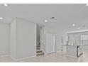 Open-concept living space with staircase and a view of the kitchen, featuring neutral tile floors at 10426 Folly Beach Rd, Orlando, FL 32827