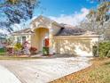 Charming single-story home with a red front door, manicured landscaping and a two car garage at 1121 Magnolia Blossom Ct, Apopka, FL 32712