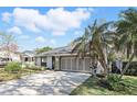 Inviting home with a well-manicured lawn, palm trees, and an attached two-car garage at 1412 Borg Ln, Winter Springs, FL 32708