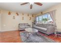 Inviting living room with hardwood floors, ceiling fan, lots of wall decorations, large window and comfortable seating at 1503 Wisconsin Ave, St Cloud, FL 34769