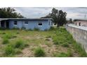 A view of the home's backyard and a partially viewed fenced area, and overgrown vegetation at 1606 26Th St, Orlando, FL 32805