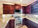 Kitchen featuring stainless steel appliances, custom cabinetry, and granite counters at 172 Balmy Coast Rd, Groveland, FL 34736