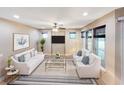 Bright living room with neutral tones, large windows, and stylish furniture at 172 Balmy Coast Rd, Groveland, FL 34736