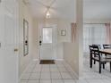 Bright foyer with tile flooring, a decorative front door, and access to the dining area at 1739 Nectarine Trl, Clermont, FL 34714