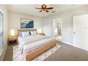 Cozy bedroom featuring a neutral color scheme, a ceiling fan, and an ensuite bathroom at 240 Whispering Pines Way, Davenport, FL 33837