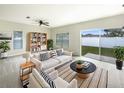 Bright living room with neutral decor, a ceiling fan, and sliding glass door access to the backyard at 240 Whispering Pines Way, Davenport, FL 33837