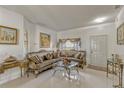 Elegant living room featuring a large window, stylish furniture, and white tile flooring at 372 Aylesbury Ct, Kissimmee, FL 34758