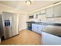 Modern kitchen with stainless steel appliances, white subway tile backsplash, and wood-look floors at 430 Pennsylvania Ave, Winter Garden, FL 34787