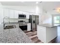 Modern kitchen boasts white cabinetry, stainless appliances, and granite countertops at 4790 Sw 166Th Loop, Ocala, FL 34473