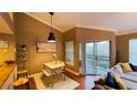 Living room with dining area, sliding glass door to the balcony, and wood flooring at 5017 City St # 1932, Orlando, FL 32839