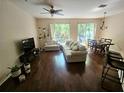 Sunlit living room with hardwood floors, plush sofa, and sliding glass doors to the outside at 554 Pinebranch Cir, Winter Springs, FL 32708