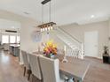 Dining room with hardwood floors, a modern chandelier, and seating for six at 565 Big Pine Ave, Minneola, FL 34715