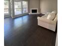 Sunlit living room featuring sleek dark floors, fireplace, large windows and a white sofa at 631 Grenadine Ct # 631, Winter Park, FL 32792