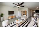 Stylish living room featuring neutral tones, a modern ceiling fan and an open layout for comfortable living at 944 Brooklet Dr, Davenport, FL 33837