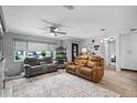 Comfortable living room with ceiling fan, modern furniture, large rug, and ample natural light at 9729 Heatherwood Ct, Orlando, FL 32825