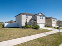 View of neutral-colored two-story home with manicured lawn and driveway on a sunny day at 1217 Michelangelo Ln, Winter Haven, FL 33884