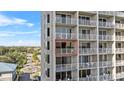 Exterior balcony view of a high-rise condo showcasing large windows, a balcony, and a view of palm trees at 13415 Blue Heron Beach Dr # 610, Orlando, FL 32821