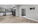 Open-concept kitchen and living area with stainless steel appliances and modern flooring at 144 Delespine Dr, Debary, FL 32713