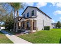 View of a two-story home showcasing its side and front with well-maintained green lawn and palm trees at 15088 Night Heron Dr, Winter Garden, FL 34787