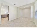 Spacious open living area with tile flooring, with view of the kitchen beyond the pillar at 15088 Night Heron Dr, Winter Garden, FL 34787