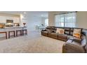 Open concept living space with a leather sofa, stools at the breakfast bar, and an adjacent dining area at 1750 Eagle Hammock Blvd, Eagle Lake, FL 33839