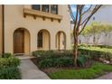 Inviting home exterior features arched entryway, well-maintained landscaping, and a pathway leading to the front door at 1859 Britlyn Aly, Orlando, FL 32814