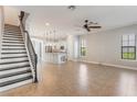 Open-concept living area with tiled floors, a ceiling fan, and staircase leading to the upper level at 1859 Britlyn Aly, Orlando, FL 32814