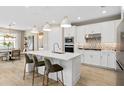 Modern kitchen featuring a central island, stainless steel appliances, pendant lighting, and ample counter space at 1941 Spring Shower Cir, Kissimmee, FL 34744