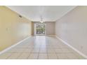 Open living room with tile floors, ceiling fan, and sliding doors leading to a balcony at 1948 Lake Atriums Cir # 129, Orlando, FL 32839