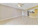 Open living room with tile floors leading to an open kitchen with stainless appliances at 1948 Lake Atriums Cir # 129, Orlando, FL 32839