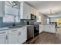 Well-lit kitchen featuring stainless steel appliances, white cabinetry, granite counters and a dining area at 2812 Mulford Ave, Winter Park, FL 32789