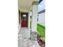Covered front porch with a red door and decorative stone pillars at 3352 Cup Dr, Lakeland, FL 33803