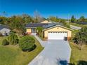 Charming yellow home with solar panels, long driveway and lush green yard at 401 Cart Ct, Kissimmee, FL 34759