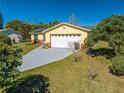 Charming yellow home with a well-maintained lawn and a long driveway at 401 Cart Ct, Kissimmee, FL 34759